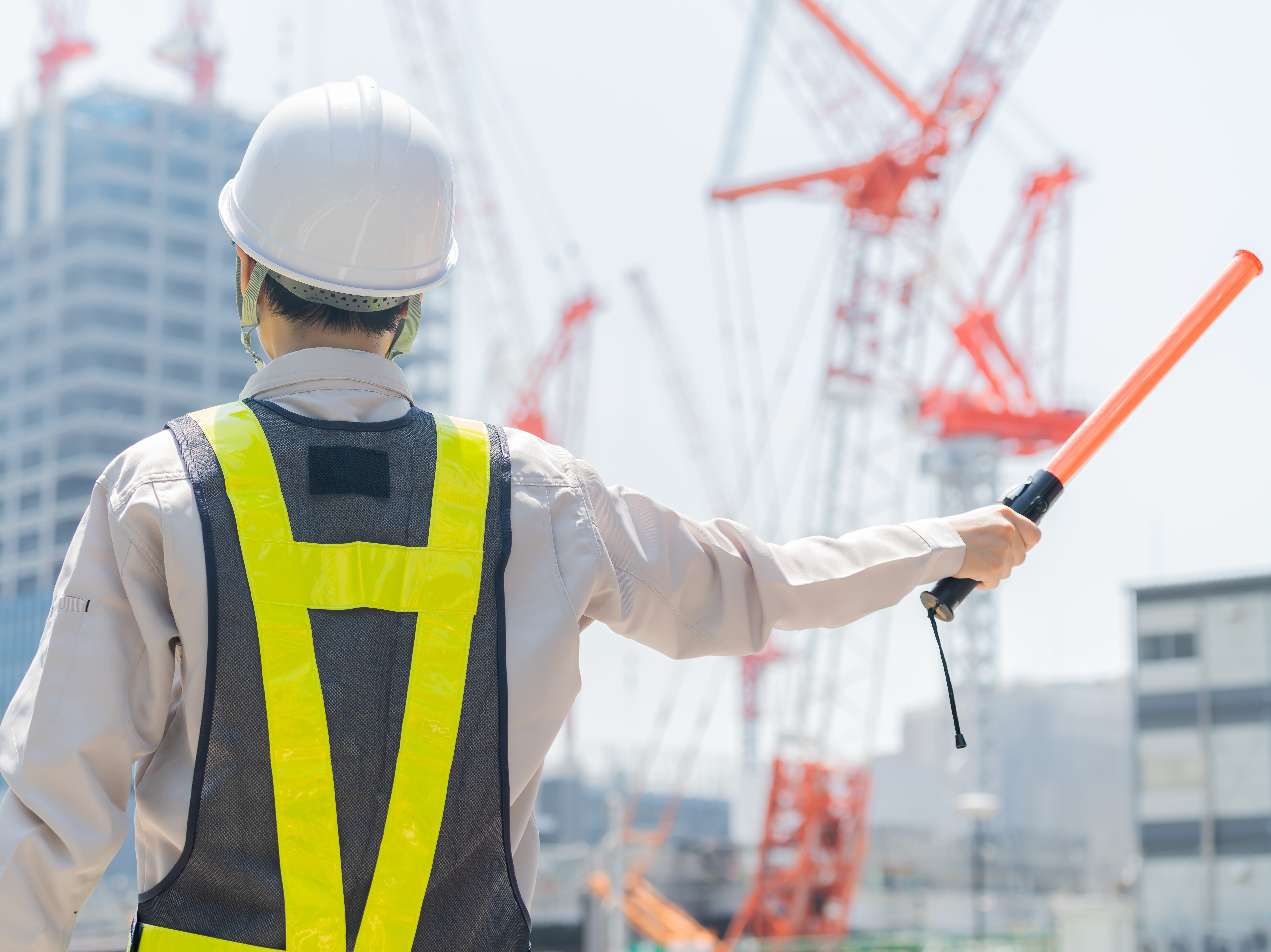 誘導棒を持ち仕事をする日本人女性